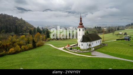 Kirche St. Johannes der täufer in bohinjska bela, slowenien, dominiert die Herbstlandschaft Stockfoto