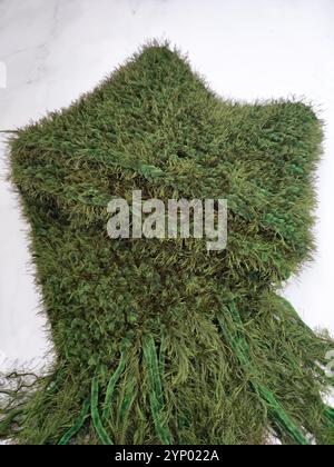 Grüner Strickschal, Fransen, Moos-Textur Graspelschal, langer flauschiger Schal auf weißem Marmorhintergrund flacher Lay, Accessoire, Kleidung Stockfoto