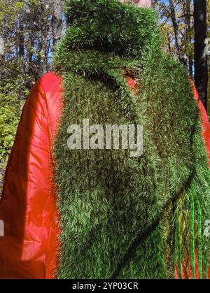 Grüner Strickschal mit Fransen im Herbst-Outfit, Damenkleidung, Schal mit Moosstruktur und Grasfell, langer flauschiger Schal im Herbstwald, Samtschal Stockfoto