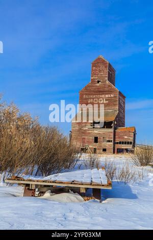 Ein großer brauner Kornelevator im Winter. Das Gebäude ist alt und verlassen Stockfoto