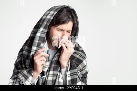 Kranker Mann mit Serviette und Tropfen für Nase in den Händen Stockfoto