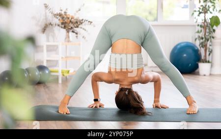 Erfahrene Mädchen Fitness Club Lehrer führt Prasarita Padottanasana Stockfoto