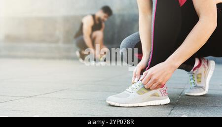 Mann und Frau Schnürsenkel binden, bevor sie im Freien Stockfoto