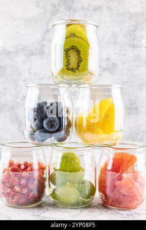 Antioxidative und entzündungshemmende Früchte, Granatapfel, Orange, Kiwi, Heidelbeere, Grapefruit und Grapefruit in Glasgefäßen, die eine Pyramide bilden. Konzept von d Stockfoto