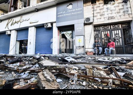 Beirut, Libanon. November 2024. Libanesen sitzen vor ihrem zerstörten Haus und geben ihre Häuser mit Fahrzeugen zurück, nachdem das Waffenstillstandsabkommen zwischen Israel und dem Libanon am 27. November 2024 in der Region Dahieh in Beirut, Libanon, in Kraft getreten ist. Foto von FADEL ITANI/UPI. Quelle: UPI/Alamy Live News Stockfoto