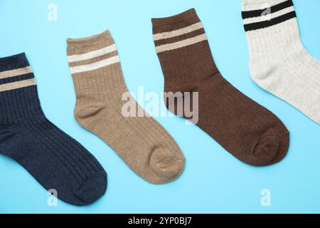 Verschiedene bequeme Socken auf hellblauem Hintergrund, flach geschnitten Stockfoto