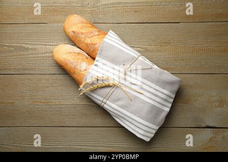 Frische Baguettes und Stacheln auf Holztisch, Blick von oben Stockfoto