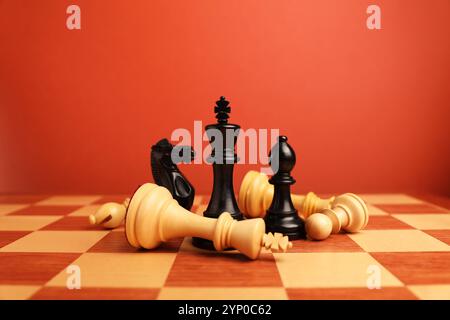 Schwarze Schachfiguren und andere gefallene weiße auf dem Schachbrett. Wettbewerbskonzept Stockfoto