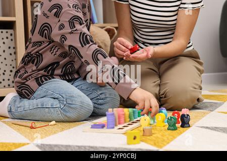 Autismustherapie. Psychologe und kleiner Junge, der drinnen mit pädagogischem Spielzeug spielt, Nahaufnahme Stockfoto