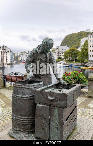 Alesund Norwegen, Statue am Hafen einer Fischerin, die den Fischfang in ein Fass zum Salzen sortiert, Skandinavien, Europa, 2024 Stockfoto