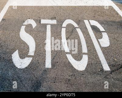 Stoppschild weiß auf dem Straßenasphalt lackiert Stockfoto