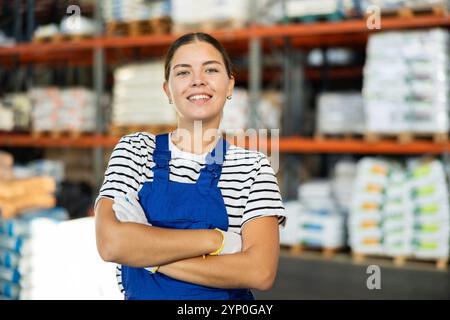 Positiver Lagermädchen steht mit überkreuzten Armen über der Brust. Stockfoto