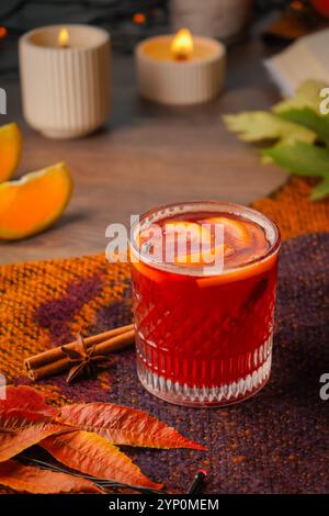 Weihnachtlicher Glühwein mit Rotwein mit Gewürzen, Äpfeln und Beeren vor herbstlichem Hintergrund. Ein traditionelles Heißgetränk für Weihnachten und Winterferien Stockfoto