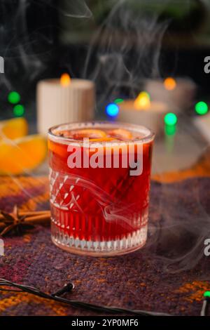 Aromatisches Punschgetränk und Zutaten auf einem Holztisch. Glühwein Rotwein mit Gewürzen und Orange im Glas. Hausgemachtes Weihnachtsgetränk Stockfoto