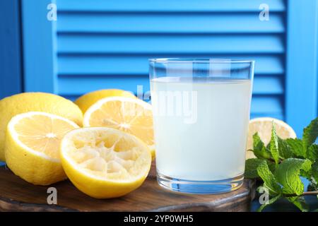 Frischer Saft im Glas, Zitronen und Minze auf dem Tisch, Nahaufnahme Stockfoto