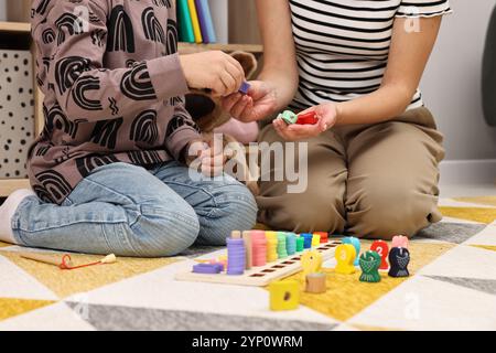 Autismustherapie. Psychologe und kleiner Junge, der drinnen mit pädagogischem Spielzeug spielt, Nahaufnahme Stockfoto