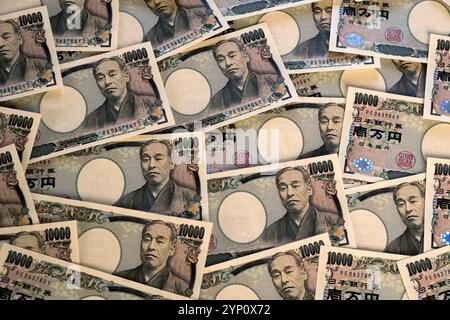 Muster des japanischen Yen in großen 10.000-Yen-Banknoten, die ein Hintergrundbild der Finanzen, des Handels, des Bankwesens, der Wirtschaft oder des Vermögens in Japan erzeugen. Stockfoto