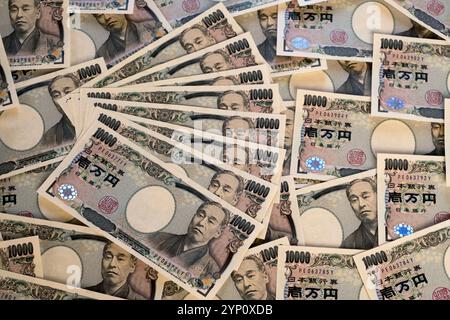 Muster des japanischen Yen in großen 10.000-Yen-Banknoten, die ein Hintergrundbild der Finanzen, des Handels, des Bankwesens, der Wirtschaft oder des Vermögens in Japan erzeugen. Stockfoto