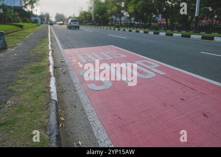 Balikpapan, Indonesien - 3. September 2024. Nahaufnahme eines Bushalteschilds auf dem Gehweg. Stockfoto