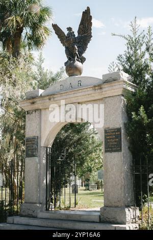 Eingang zum historischen Colonial Park Cemetery in der Innenstadt von Savannah, Georgia, mit einem kunstvollen Eisentor, der von spanischem Moos und Bäumen eingerahmt ist Stockfoto