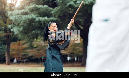 Holzschwert, japanische Frau und Outdoor in Training, Sport und Sport für Kampfkunst oder Aikido. Schüler, Waffen und Erbe mit Herausforderung Stockfoto