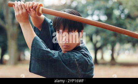 Holzschwert, japanischer Mann und Outdoor für Kampfkünste in Training, Sport und Kultur. Person, Waffe und Erbe für Herausforderung und Kampf Stockfoto