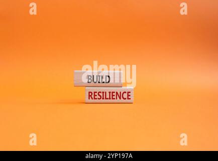Symbol für Belastbarkeit erstellen. Holzklötze mit Wörtern sorgen für Widerstandsfähigkeit. Wunderschöner orangefarbener Hintergrund. Business- und Build Resilience-Konzept. Kopierbereich. Stockfoto