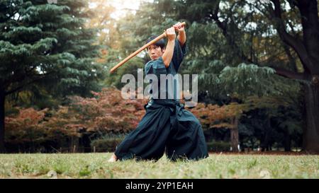 Holzschwert, japanischer Mann und Outdoor im Sport, Training und Training für Kampfkunst oder Aikido. Männliche Person, Waffe und Erbe für die Herausforderung Stockfoto