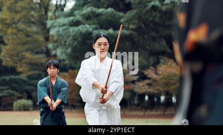 Waffen, Japaner und Outdoor im Training, Training und Sport für Kampfkunst oder Aikido. Schüler, Holzschwert und Erbe mit Herausforderung Stockfoto