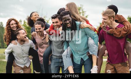 Verschiedene Gruppen von Millennials-Freunden genießen echte Momente des Glücks im Freien. Authentisches Lifestyle-Porträt multiethnischer Jugendlicher lachen A Stockfoto