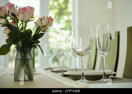 Esstisch mit Rosen und Gläsern Stockfoto
