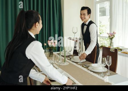Lächelnde Kellner, Die Einen Eleganten Dinner-Service Einrichten Stockfoto