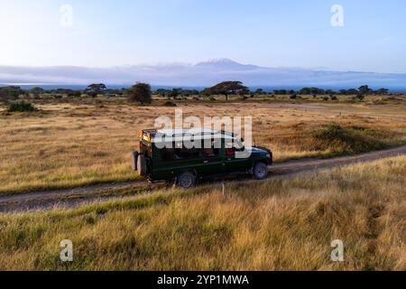 Amboseli-Nationalpark, Kenia. Der SUV mit offenem Dach fährt am Nachmittag durch die Savanne. Safari-Safari-Safari mit dem Gnus, Rise Stockfoto