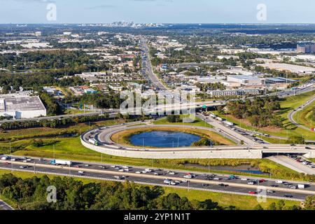 Aus der Vogelperspektive auf der Kreuzung mit Floridas Turnpike und Martin Andersen Beachline Expy mit der Innenstadt im Hintergrund in Orlando, U Stockfoto