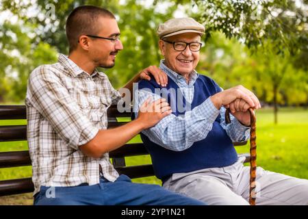 Porträt von glücklichem Großvater und Enkel im Park. Sie verbringen Zeit miteinander und haben Spaß. Stockfoto