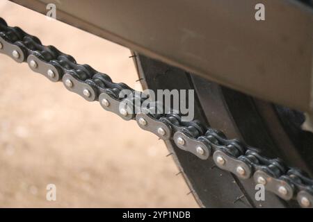 Ansicht einer Kette vom Motorrad. Die Ketten, die die Räder antreiben, sind über Kettenglieder mit dem Motor verbunden Stockfoto