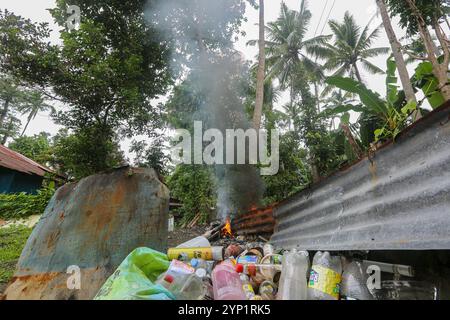 Laguna, Philippinen. 28. November 2024: Müllfeuer am Rande eines Waldes. Viele Filipinos verbrennen Müll in Hinterhöfen, eine häufige Ursache für Fehden in der Nachbarschaft. Das Gesetz verbietet offenes Abbrennen, aber diese umweltschädliche und schädliche Praxis namens „Pagsisiga“ ist in ländlichen Gebieten weit verbreitet. Dämpfe und Verbrennungsrückstände von Haushaltsabfällen, Elektronik, Kunststoff, Synthetik, Chemie, Pappe, organische Materialien verschmutzen Umwelt, Grundwasser und Luft. Die fünfte Sitzung des zwischenstaatlichen Verhandlungsausschusses für Kunststoffverschmutzung (INC-5) findet diese Woche in Südkorea statt. Quelle: Kevin Izorce/Alamy Live News Stockfoto