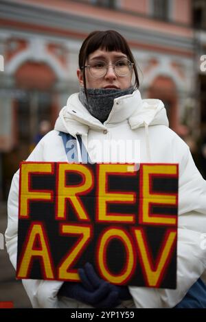 Junge Frau demonstriert mit einem Poster Freies Asov in der Ukraine. Kiew - 24. November 2024 Stockfoto