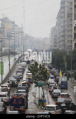 Beirut, Libanon. November 2024. Fahrzeuge, die Menschen nach Hause transportieren, sitzen am 27. November 2024 in einem Stau im südlichen Vorort Beirut im Libanon fest. Das israelische Sicherheitskabinett hat am Dienstagabend ein Waffenstillstandsabkommen mit dem Libanon gebilligt und damit den Weg für ein Ende eines fast 14-monatigen Konflikts geebnet, der größtenteils mit dem andauernden Konflikt im Gazastreifen zusammenhängt, bei dem ab Mittwoch 44.282 Palästinenser ums Leben kamen. Quelle: Str/Xinhua/Alamy Live News Stockfoto