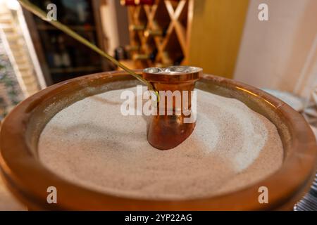 Türkischer Kaffee im Sand mit türken zubereitet. Kaffee auf heißem Sand zubereiten. Stockfoto