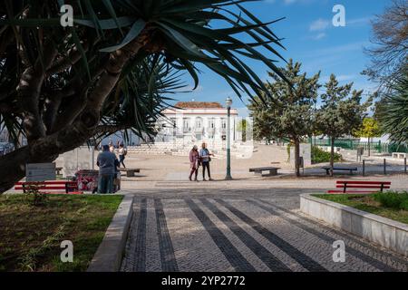 Spaziergang in der Wintersonne auf dem mit Kopfsteinpflaster gepflasterten Hauptplatz (Praca da República), Tavira, Algarve, Portugal Stockfoto