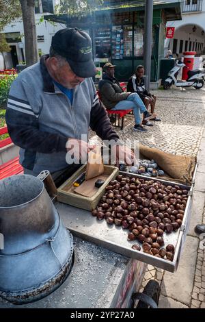 Geröstete Kastanien zum Verkauf auf dem mit Kopfsteinpflaster gepflasterten Hauptplatz República von Tavira, Algarve, Portugal Stockfoto