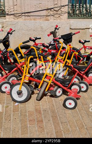 Marseille. Frankreich - 27. November 2024: Bunte Kinderdreiräder mit gelben und roten Motiven gruppiert an einem sonnigen Tag im Freien, ideal für Stockfoto