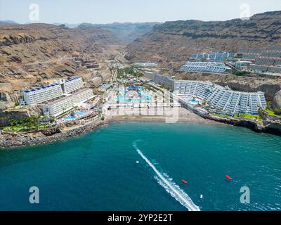 Ein atemberaubender Blick auf Gran Canarias Klippen-Resorts mit luxuriösen Unterkünften, einem lebhaften Wasserpark und einem Sandstrand entlang der Küste Stockfoto