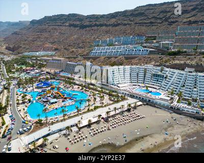 Ein atemberaubender Blick auf Gran Canarias Klippen-Resorts mit luxuriösen Unterkünften, einem lebhaften Wasserpark und einem Sandstrand entlang der Küste Stockfoto