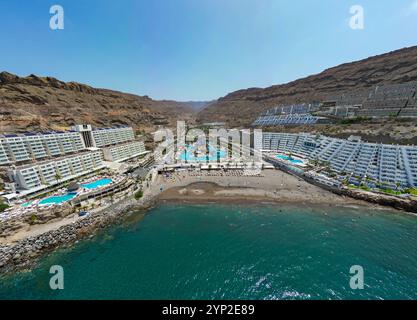 Ein atemberaubender Blick auf Gran Canarias Klippen-Resorts mit luxuriösen Unterkünften, einem lebhaften Wasserpark und einem Sandstrand entlang der Küste Stockfoto