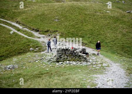 Menschen (Wanderer), die am Nan Bield Pass Stone Shelter zum Wainwright 'harter Fell' von 'Mardale ill Bell' im Lake District National Park spazieren Stockfoto