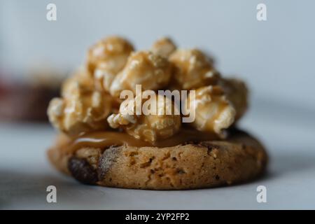 Nahaufnahme von hausgemachtem, traditionellem amerikanischem Schokoladen-Chip-Keks mit Karamell-Popcorn-Belag. Auf weißem Hintergrund. Stockfoto