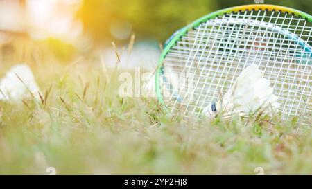 Ein Badmintonschläger und Shuttlecock auf einem grasbewachsenen Feld, symbolisiert die Freude an Outdoor-Sport, gesundes Leben und die Bedeutung von Erholunga Stockfoto