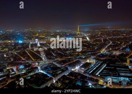 Atemberaubender nächtlicher Luftanblick auf Paris, beleuchtet von pulsierenden Lichtern der Stadt, mit goldenem Glanz und Leuchtfeuer des Eiffelturms über der urbanen Landschaft Stockfoto